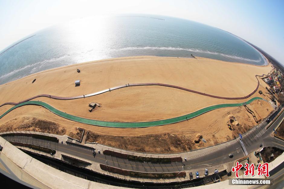 3月13日，秦皇島萬(wàn)米臨海沙灘木棧道。據(jù)了解，該木棧道全長(zhǎng)約4200米，與北戴河區(qū)原有的7500米木棧道對(duì)接后全線總長(zhǎng)度1.17萬(wàn)米，整個(gè)木棧道東起秦皇島體育基地游船碼頭，西至北戴河濕地公園，呈波浪形蜿蜒10.4公里海岸線。 中新社發(fā) 曹建雄 攝 CNSPHOTO