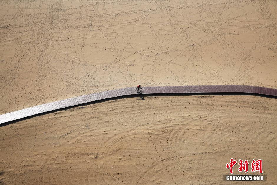 3月13日，秦皇島萬(wàn)米臨海沙灘木棧道。據(jù)了解，該木棧道全長(zhǎng)約4200米，與北戴河區(qū)原有的7500米木棧道對(duì)接后全線總長(zhǎng)度1.17萬(wàn)米，整個(gè)木棧道東起秦皇島體育基地游船碼頭，西至北戴河濕地公園，呈波浪形蜿蜒10.4公里海岸線。 中新社發(fā) 曹建雄 攝 CNSPHOTO